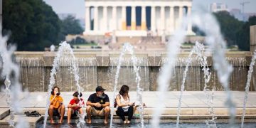 Una familia se refresca por el intenso calor durante una visita a monumentos en Washington.