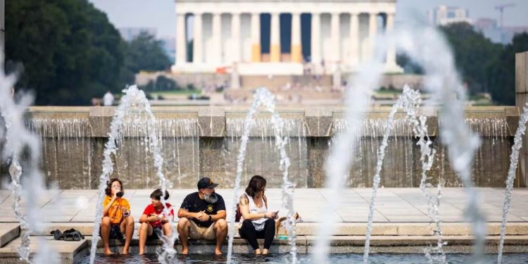 Una familia se refresca por el intenso calor durante una visita a monumentos en Washington.