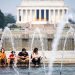 Una familia se refresca por el intenso calor durante una visita a monumentos en Washington.