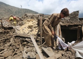 Un hombre algunas de sus pertenencias entre los escombros de su vivienda luego del terremoto en Afganistán.