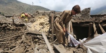 Un hombre algunas de sus pertenencias entre los escombros de su vivienda luego del terremoto en Afganistán.