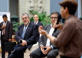 El presidente Bernardo Arévalo y el titular de Segeplan, Carlos Mendoza, escuchan el testimonio de un joven beneficiario del programa Becas por nuestro futuro.