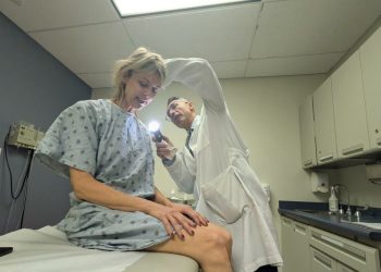 Las camas solares aumentan el riesgo de padecer melanoma. El doctor Pedram Gerami, uno de los autores del estudio, examina a una paciente.