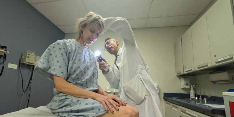 Las camas solares aumentan el riesgo de padecer melanoma. El doctor Pedram Gerami, uno de los autores del estudio, examina a una paciente.