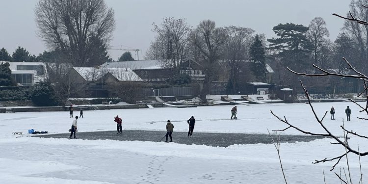Algunas personas patinan sobre el hielo en un brazo del río Danubio, que se congeló a causa del frío extremo.