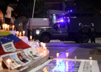 En un altar instalado en la afueras de una prisión venezolana se exhiben fotografías de presos políticos por quienes se pide su liberación.