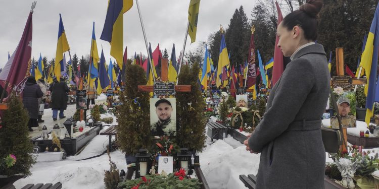 Irina Farion, de 40 años, viuda del soldado voluntario ucraniano Oleksandr Alimov, visita su tumba en el cuarto aniversario de la invasión rusa en Ucrania.