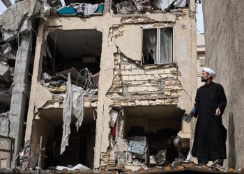 Un clérigo trabaja en la un edificio atacado en la calle Rajaei del sureño barrio de 13 de Aban, en la capital Teherán, Irán, que fue bombardeado en la madrugada por Estados Unidos e Israel donde trabajaban desescombrando. / Foto: EFE, Jaime León.