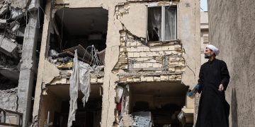 Un clérigo trabaja en la un edificio atacado en la calle Rajaei del sureño barrio de 13 de Aban, en la capital Teherán, Irán, que fue bombardeado en la madrugada por Estados Unidos e Israel donde trabajaban desescombrando. / Foto: EFE, Jaime León.