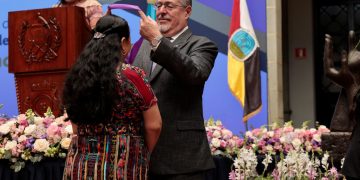 El presidente Arévalo impone medalla a una de las galardonadas con la Orden a la Excelencia Laboral.