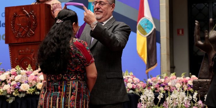 El presidente Arévalo impone medalla a una de las galardonadas con la Orden a la Excelencia Laboral.