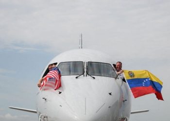 Poco antes de despegar, los pilotos del avión de American Airlines celebraron con las banderas de Estados Unidos y Venezuela.