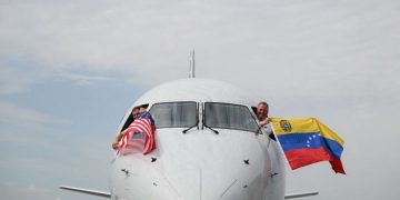 Poco antes de despegar, los pilotos del avión de American Airlines celebraron con las banderas de Estados Unidos y Venezuela.