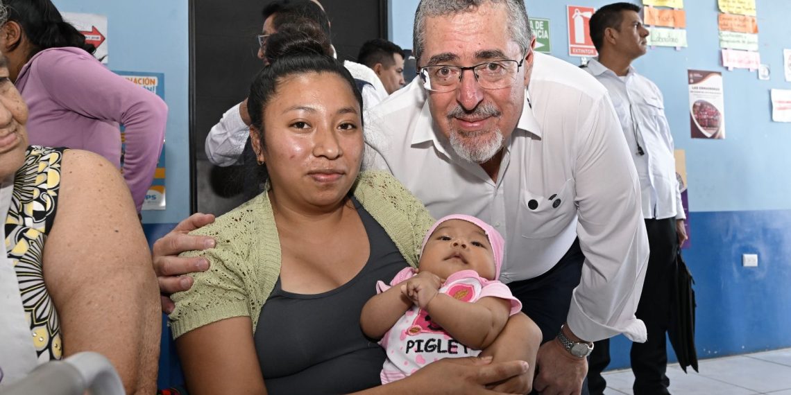 El presidente Bernardo Arévalo en el Centro de Salud de Parramos, comparte con una madre que llevó a su hija por atención médica.