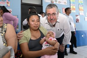 El presidente Bernardo Arévalo en el Centro de Salud de Parramos, comparte con una madre que llevó a su hija por atención médica.