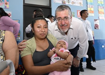 El presidente Bernardo Arévalo en el Centro de Salud de Parramos, comparte con una madre que llevó a su hija por atención médica.