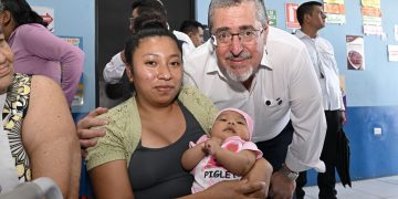 El presidente Bernardo Arévalo en el Centro de Salud de Parramos, comparte con una madre que llevó a su hija por atención médica.