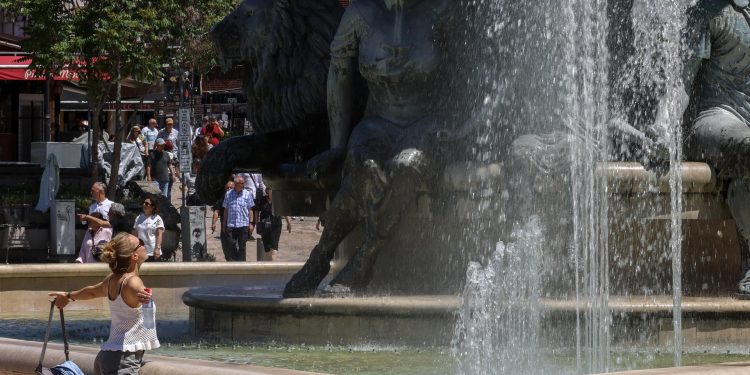 Una mujer se refresca en una fuente, en Macedonia del Norte, a causa del intenso calor que afecta gran parte de Europa.