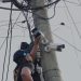 Agente de la PNC desinstala una de las cámaras de video vigilancia en la aldea Lo de Rodríguez, en la zona 18.