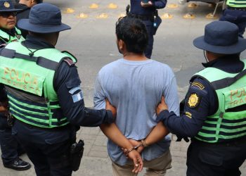 Agentes de la PNC conducen a uno de los presuntos asaltantes capturados en la carretera a El Salvador.