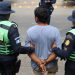 Agentes de la PNC conducen a uno de los presuntos asaltantes capturados en la carretera a El Salvador.