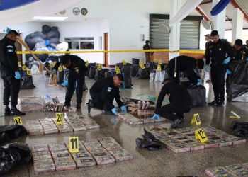 Agentes antinarcóticos custodian los bultos con la droga. Las autoridades contabilizaran 1 mil 500 kilos de cocaína.