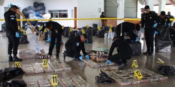 Agentes antinarcóticos custodian los bultos con la droga. Las autoridades contabilizaran 1 mil 500 kilos de cocaína.