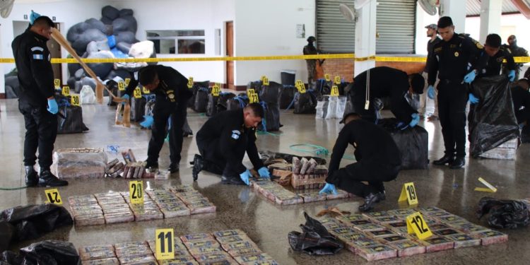 Agentes antinarcóticos custodian los bultos con la droga. Las autoridades contabilizaran 1 mil 500 kilos de cocaína.