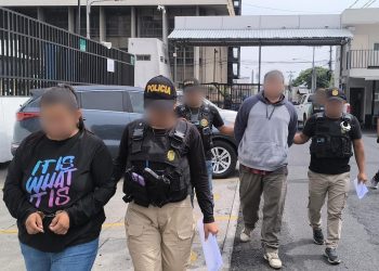 Investigadores de la DEIC conducen a dos de los detenidos en allanamientos.