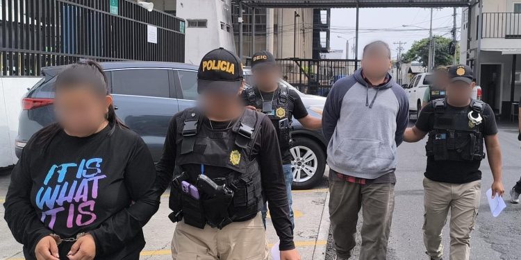 Investigadores de la DEIC conducen a dos de los detenidos en allanamientos.