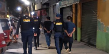 Luego de su captura por fingir secuestro, agentes policiales conducen a los supuestos secuestrador y víctima que exigían dinero a la familia por la liberación.