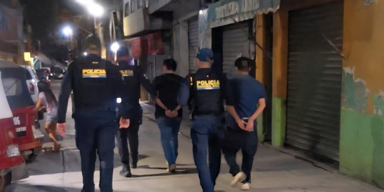 Luego de su captura por fingir secuestro, agentes policiales conducen a los supuestos secuestrador y víctima que exigían dinero a la familia por la liberación.