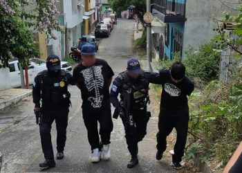 Agentes de la Comisaría 12 de la PNC conducen a los dos presuntos responsables de la muerte de concejal de Chinautla.