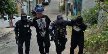 Agentes de la Comisaría 12 de la PNC conducen a los dos presuntos responsables de la muerte de concejal de Chinautla.