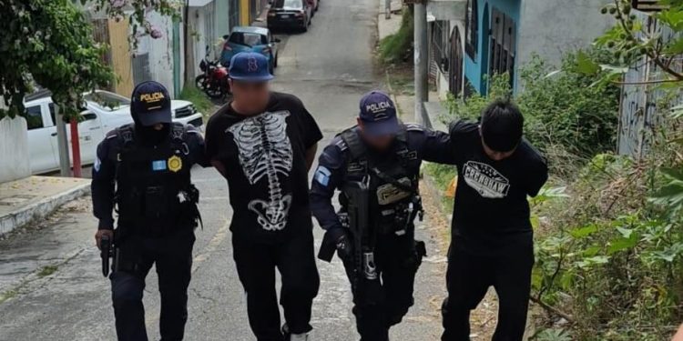 Agentes de la Comisaría 12 de la PNC conducen a los dos presuntos responsables de la muerte de concejal de Chinautla.