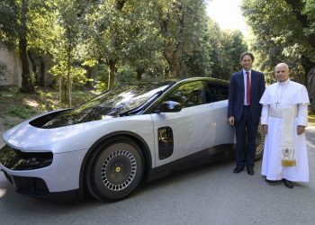 El papa León XIV y el presidente de Ferrari, junto al primer automóvil eléctrico de esa casa automotriz.