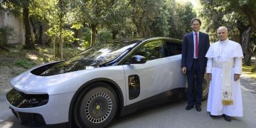 El papa León XIV y el presidente de Ferrari, junto al primer automóvil eléctrico de esa casa automotriz.