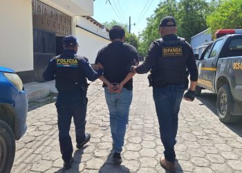 Agentes de la PNC conducen a una persona capturada durante allanamiento en Usumatlán, Zacapa.