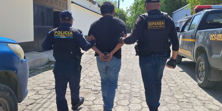 Agentes de la PNC conducen a una persona capturada durante allanamiento en Usumatlán, Zacapa.