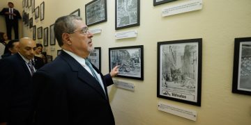 El presidente Bernardo Bernardo Arévalo, observa fotos en el museo del Insivumeh, durante su recorrido por las instalaciones de esa Institución.