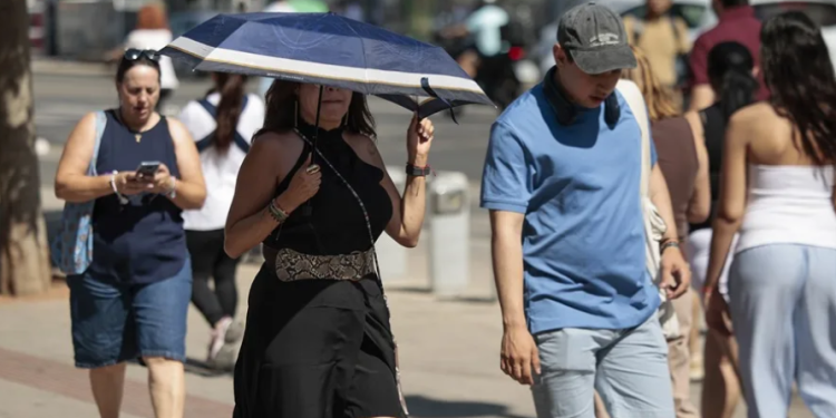 Una mujer se protege del calor con un paraguas. /Foto: EFE