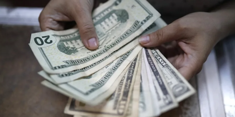 Una persona cuenta unos billetes este en San Salvador (El Salvador). EFE