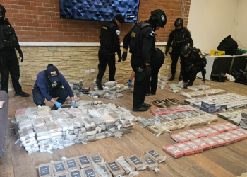 Agentes de la PNC y personal del MP examinan paquetes localizados durante el desmantelamiento del narcolaboratorio. / Foto: MP