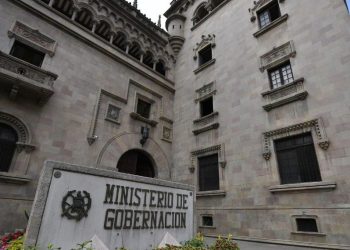 Fachada del Ministerio de Gobernación, con ventanas ornamentadas y un rótulo con el nombre de la institución en primer plano.