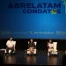 Tres panelistas conversan en un escenario frente a una pantalla con el nombre de Abrelatam/ConDatos.