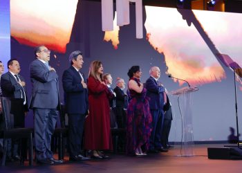 Participantes de pie en un escenario, varios con la mano derecha sobre el pecho, durante el Galardón Nacional a la Exportación 2026.
