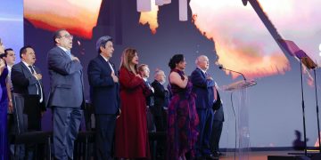 Participantes de pie en un escenario, varios con la mano derecha sobre el pecho, durante el Galardón Nacional a la Exportación 2026.