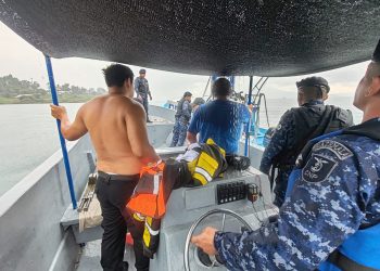 Personal naval y civiles a bordo de una embarcación en el lago de Atitlán.