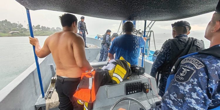 Personal naval y civiles a bordo de una embarcación en el lago de Atitlán.