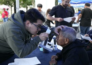 Personal de salud examina los ojos de un adulto mayor durante una jornada de atención visual.